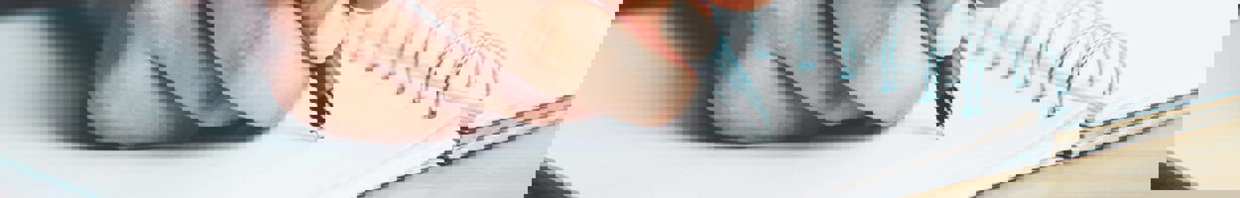 Close up of person writing in notebook
