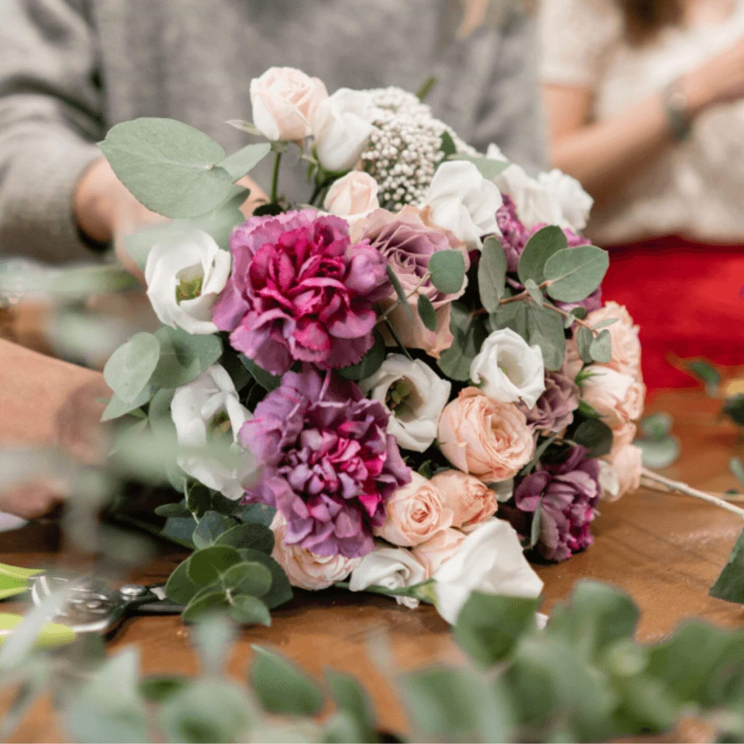 Person tying flowers together