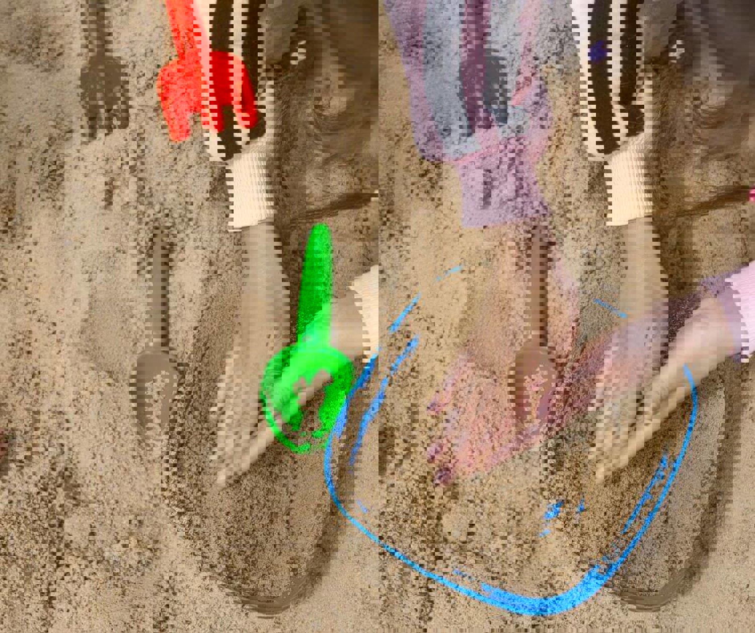 Young child's hands in sand