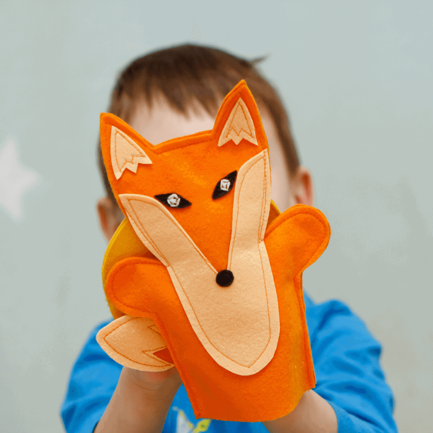 Boy holding handmade fox puppet 