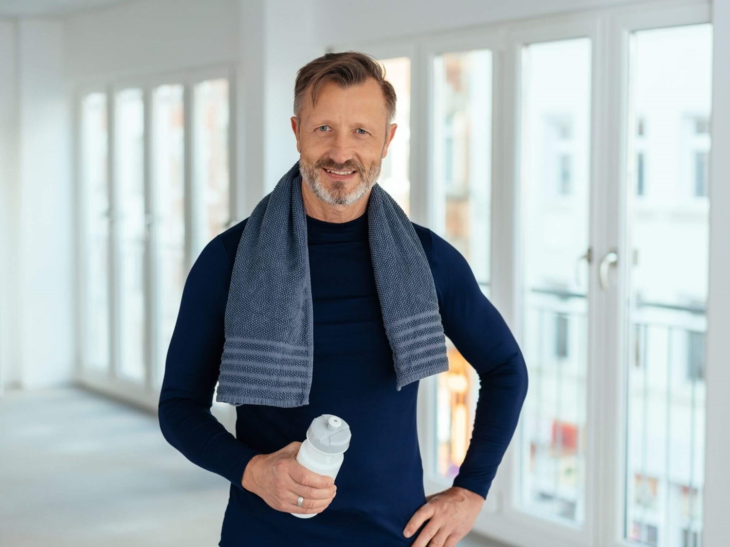 Man with towel around shoulders holding a water bottle