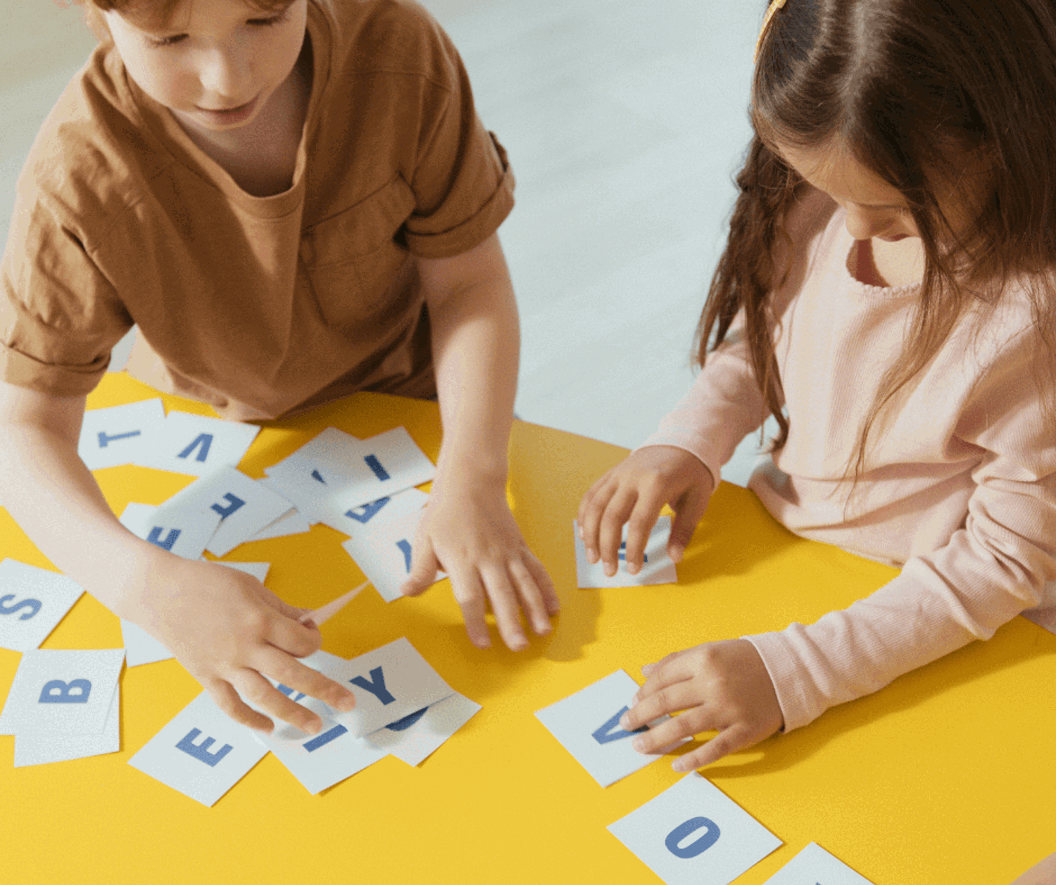 Two people playing with letter cards