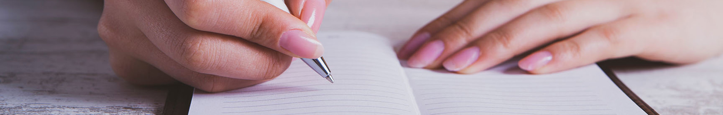Woman writing in a lined notepad