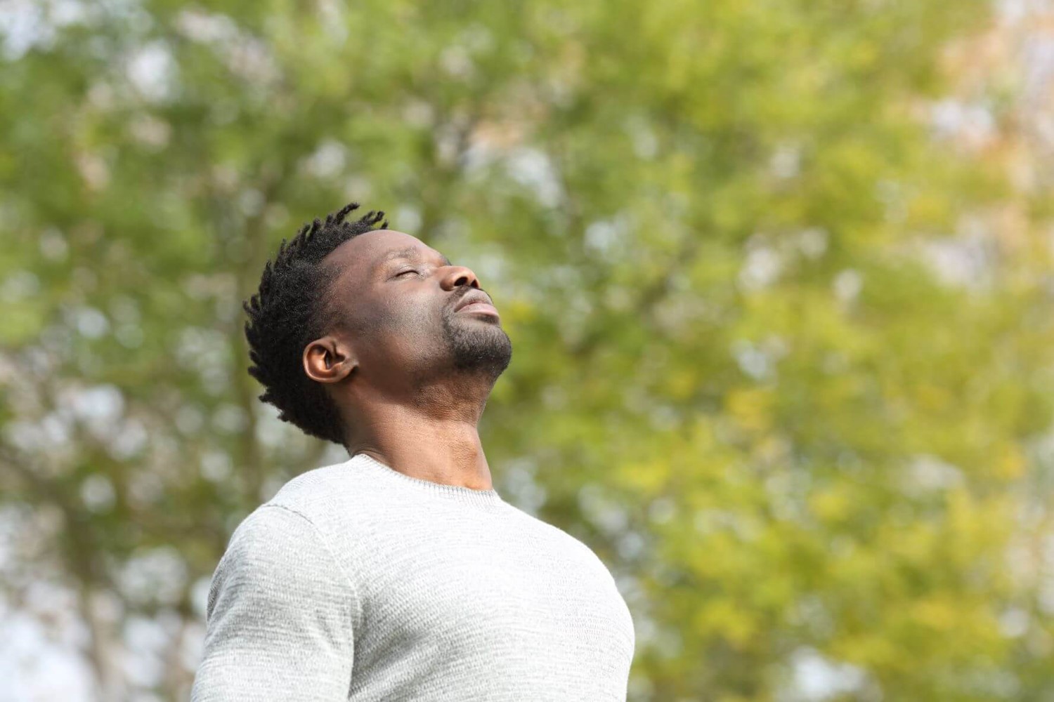 Man looking up to sky with eyes closed