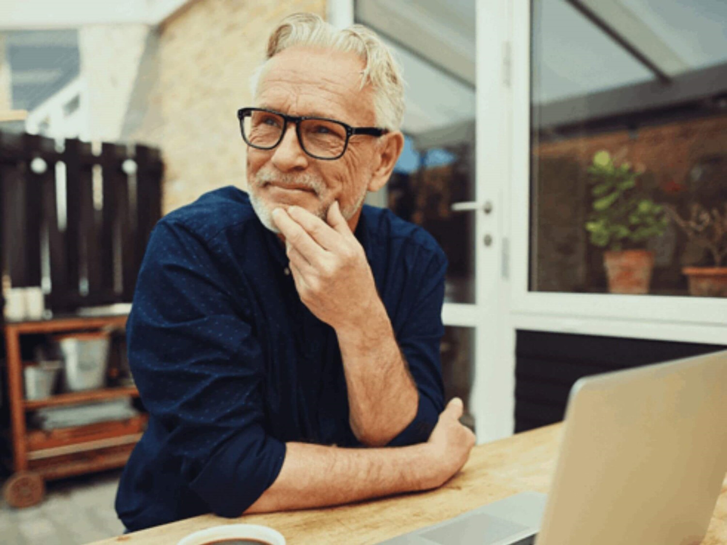 Man smiling on laptop outside