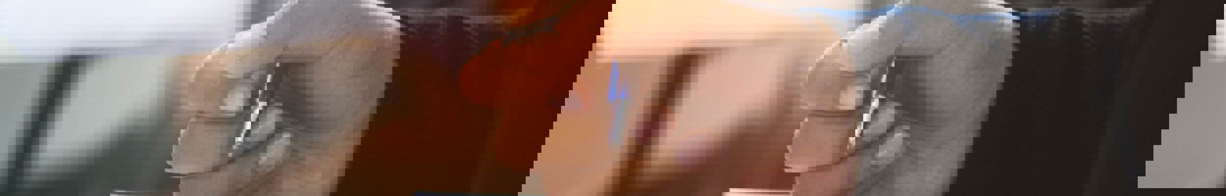 Close up of person holding pen with calculator on desk