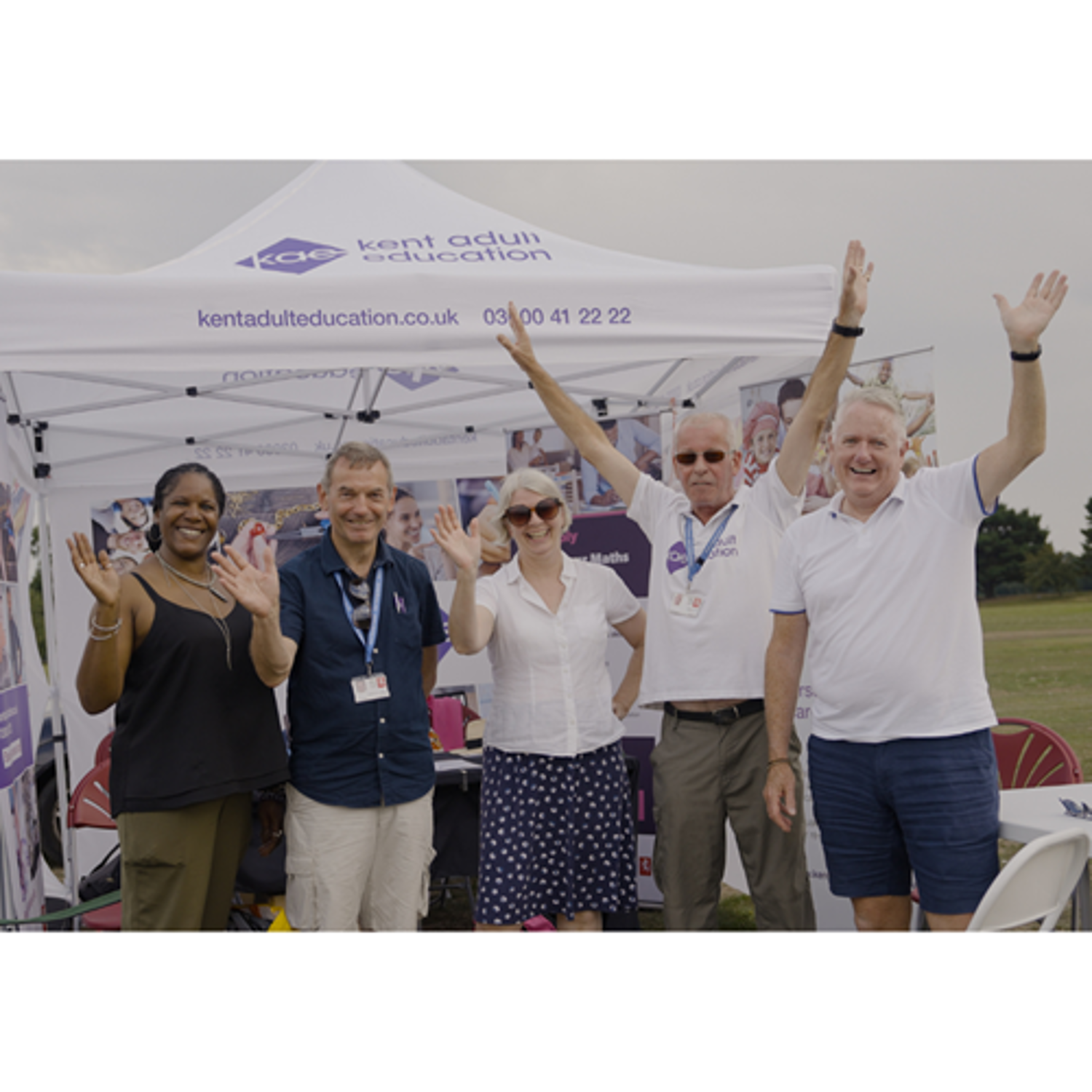 People waving at KAE stand