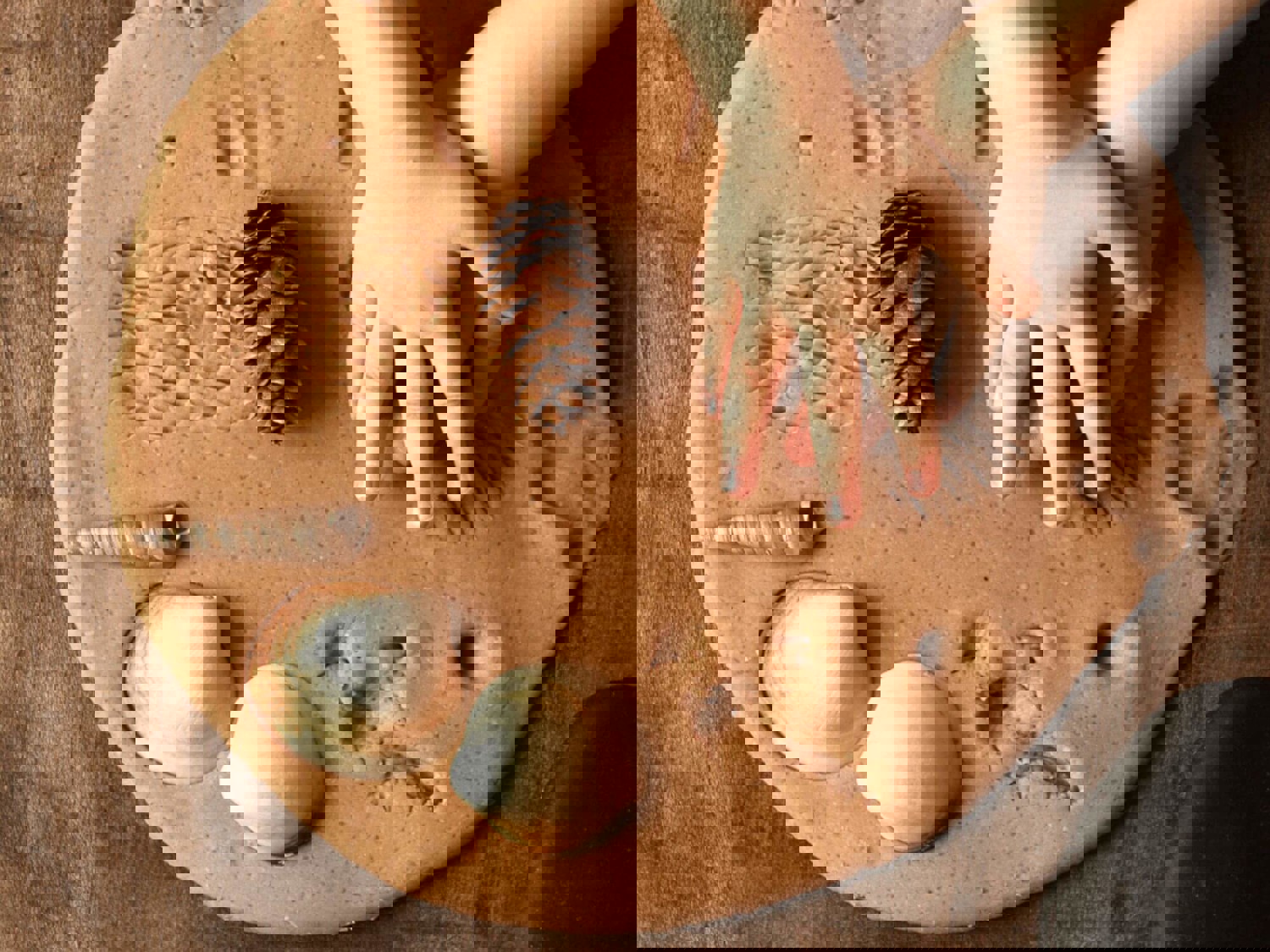 Child making hand prints in clay