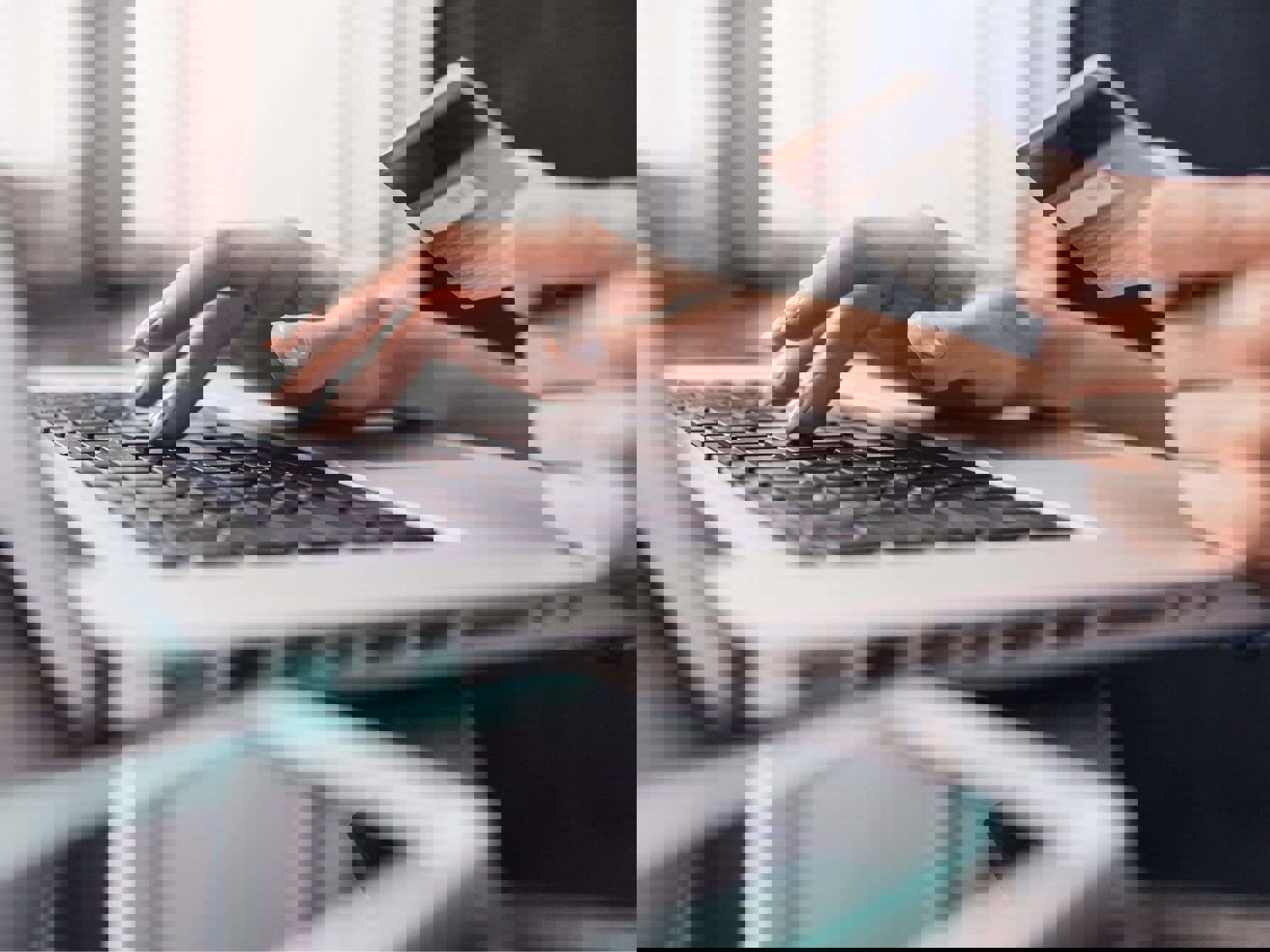 Person typing bank card details on laptop