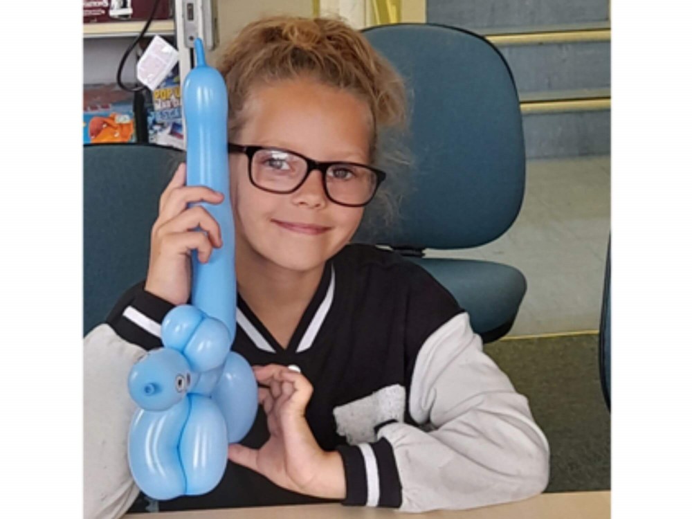 Girl smiling holding balloon animal