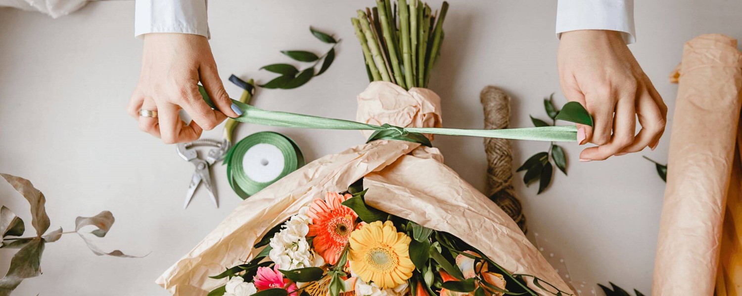 Person tying flowers together