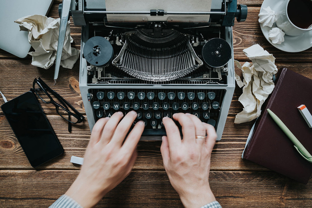 Person typing on typewriter 