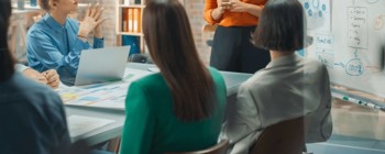 Women in meeting watching someone present