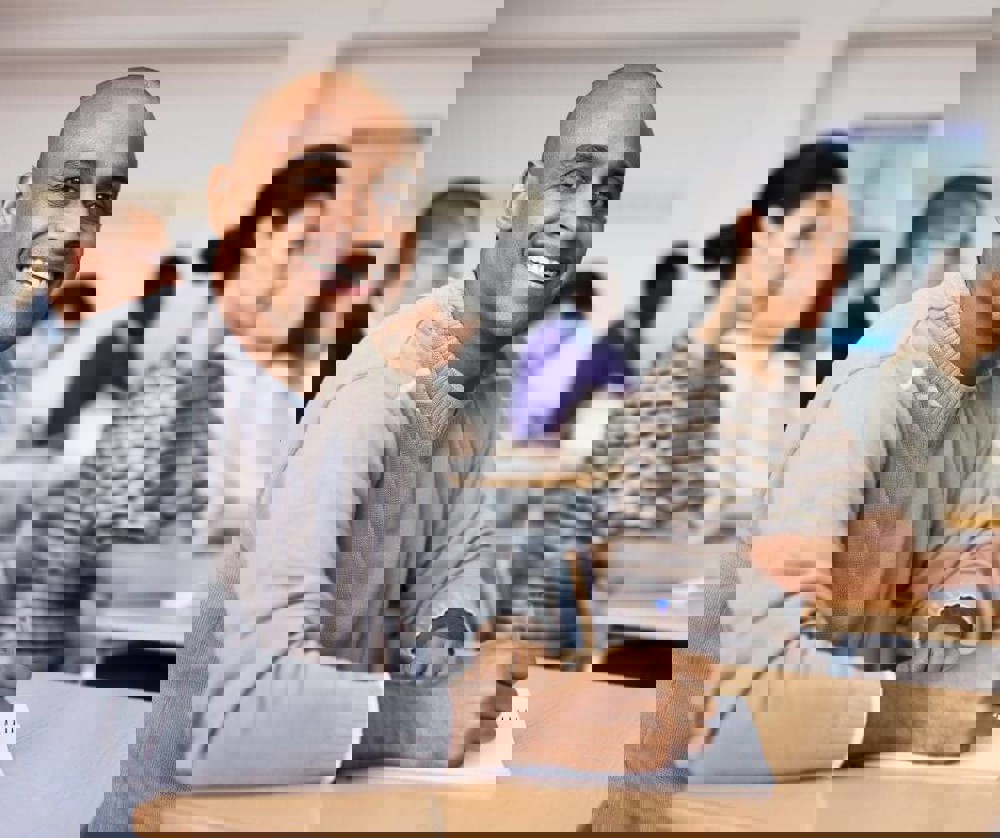 Two people sitting at a table looking at a book