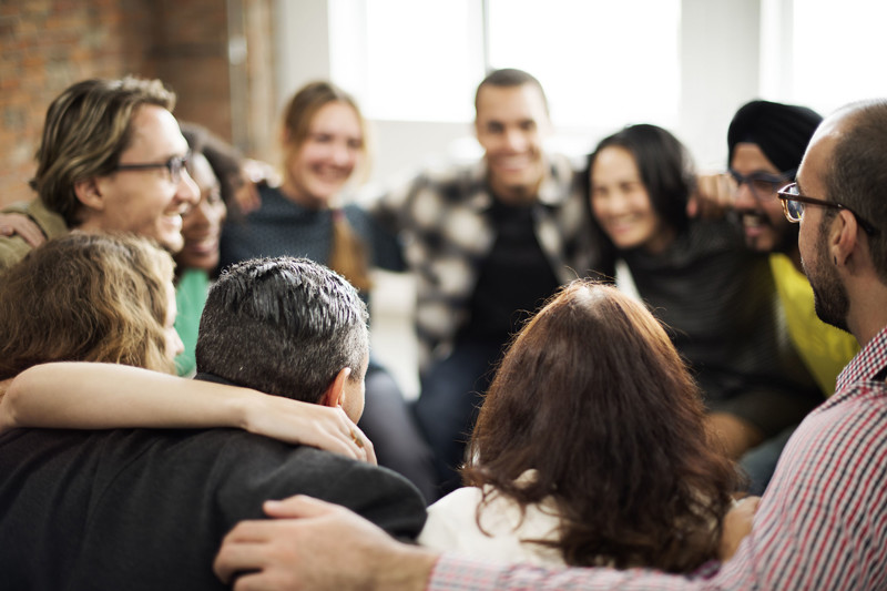 A circle of adults smiling
