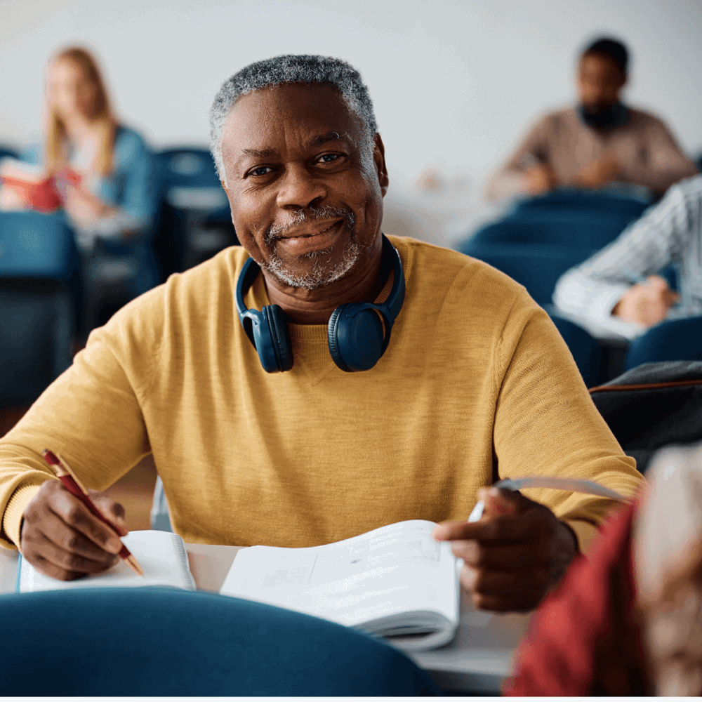 Person sitting in a classroom smiling
