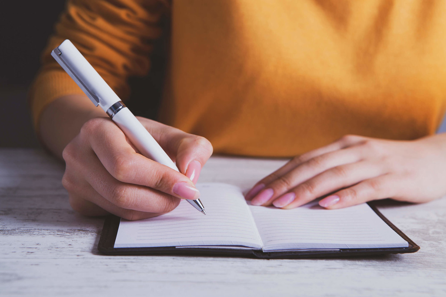 A woman writing notes in a notebook