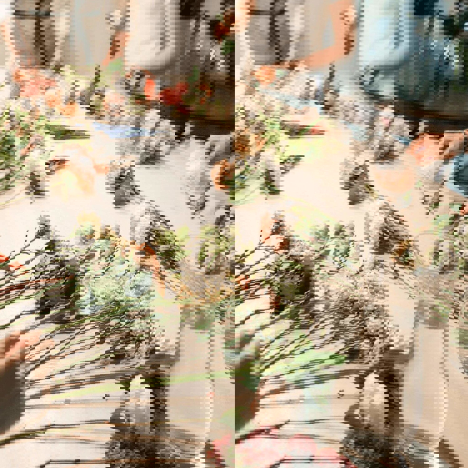 Group of people arranging flower stems on table
