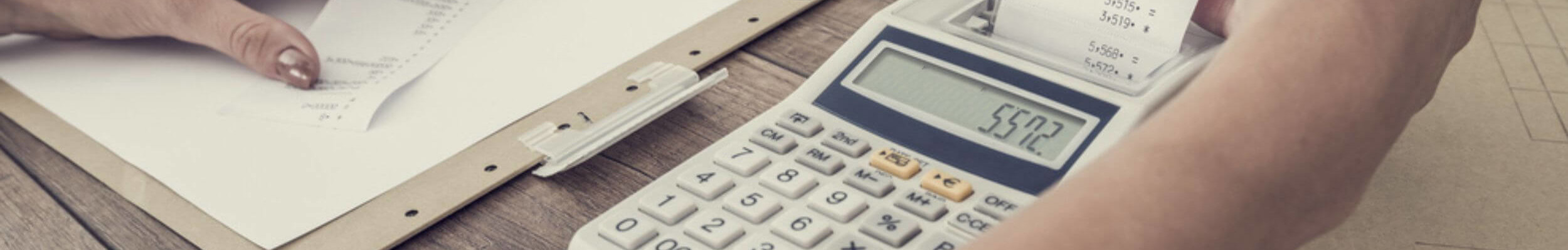 Person adding up receipts on calculator 