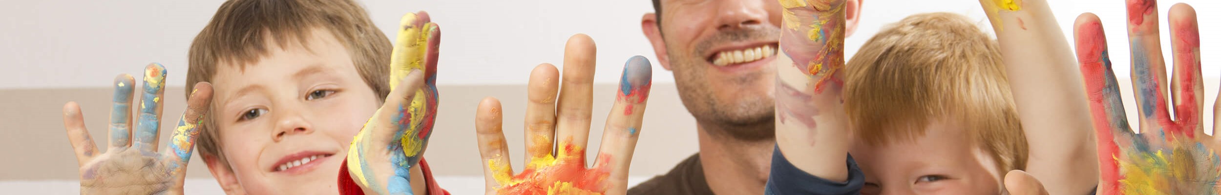 Children and father with paint on hands