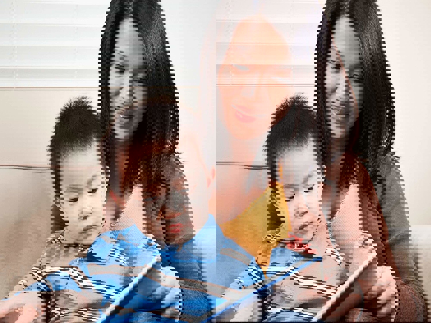 Woman reading book with boy