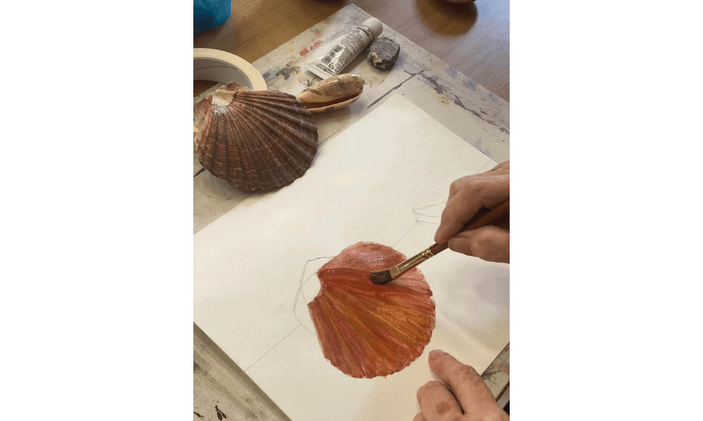 Student painting a shell