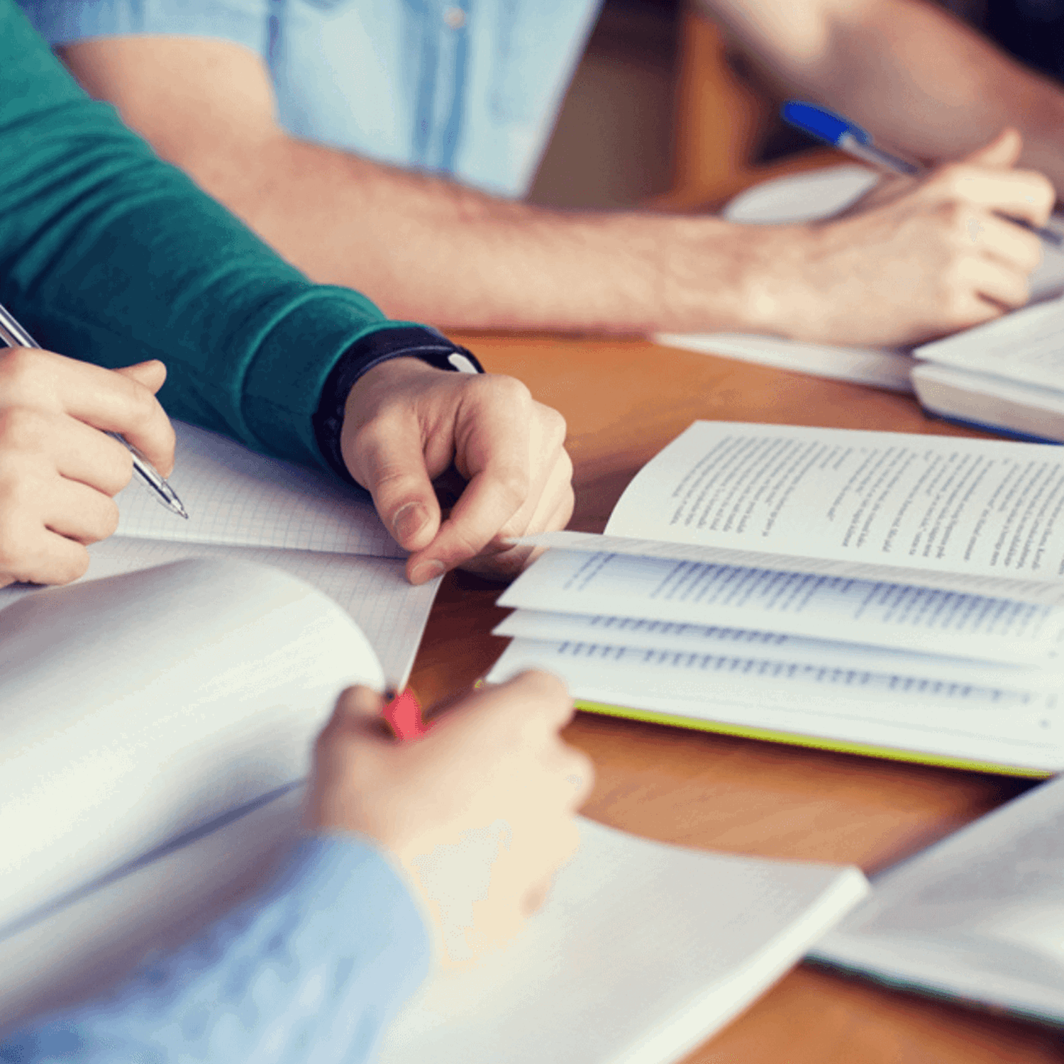 People writing in notebooks at desk