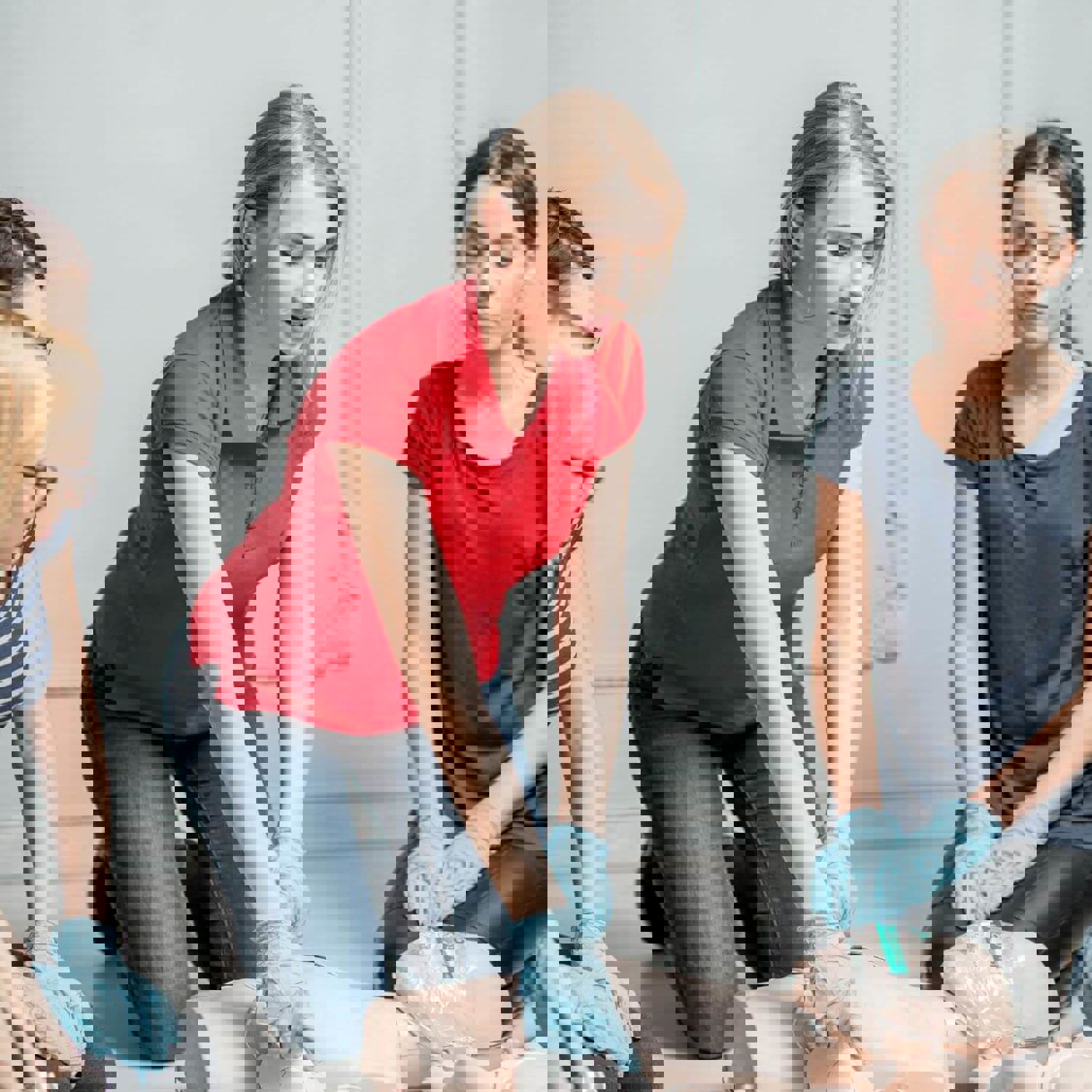 Group of people kneeling around a first aid dummy
