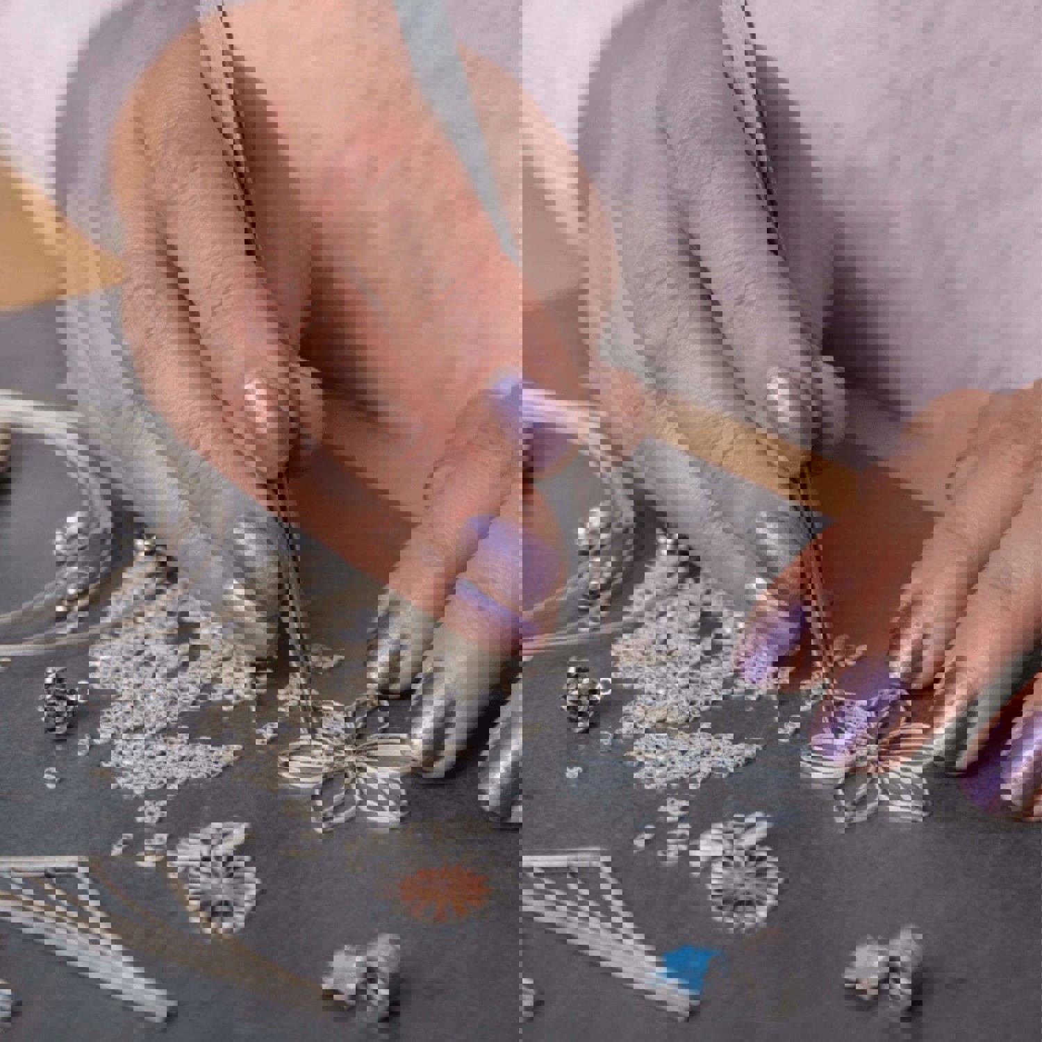 Person picking up jewellery with tweezers