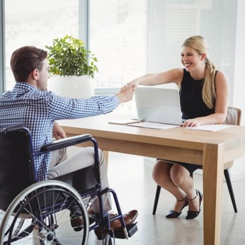 Smiling executives shaking hands across a desk