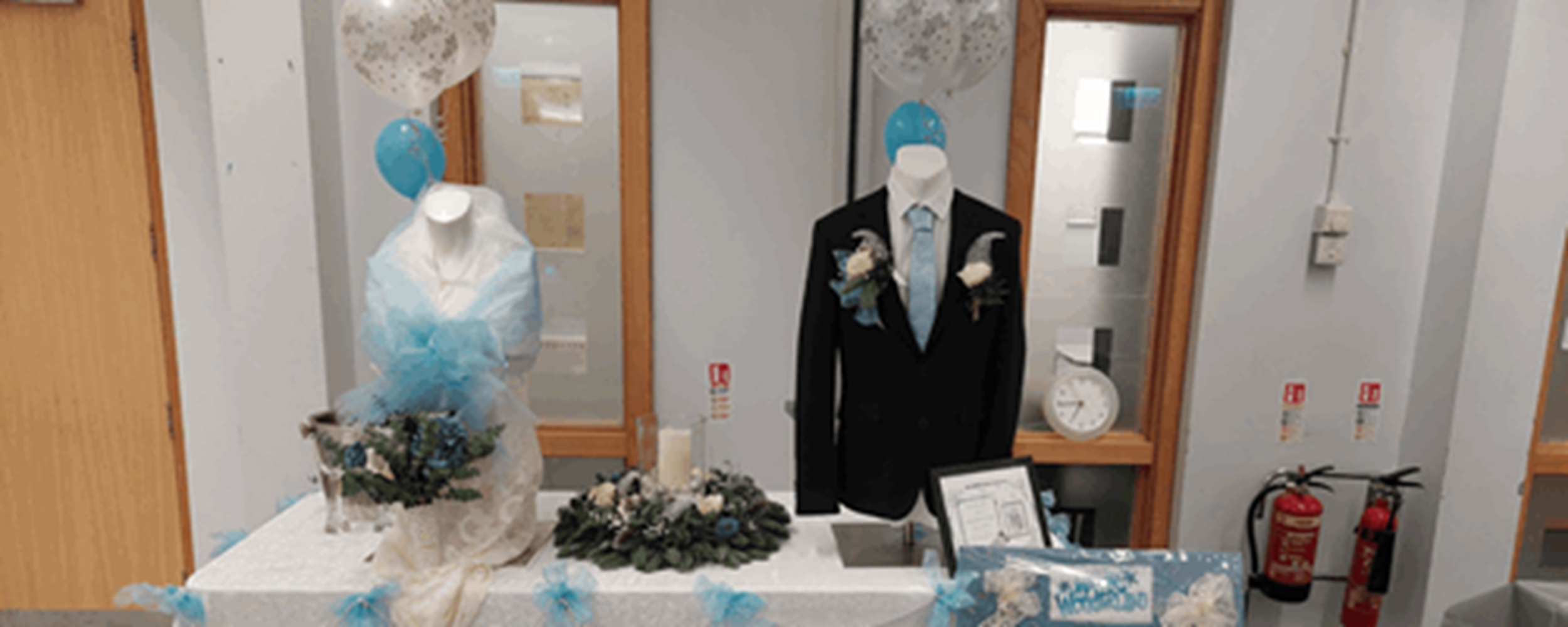 Suit and wedding dress with flowers on table