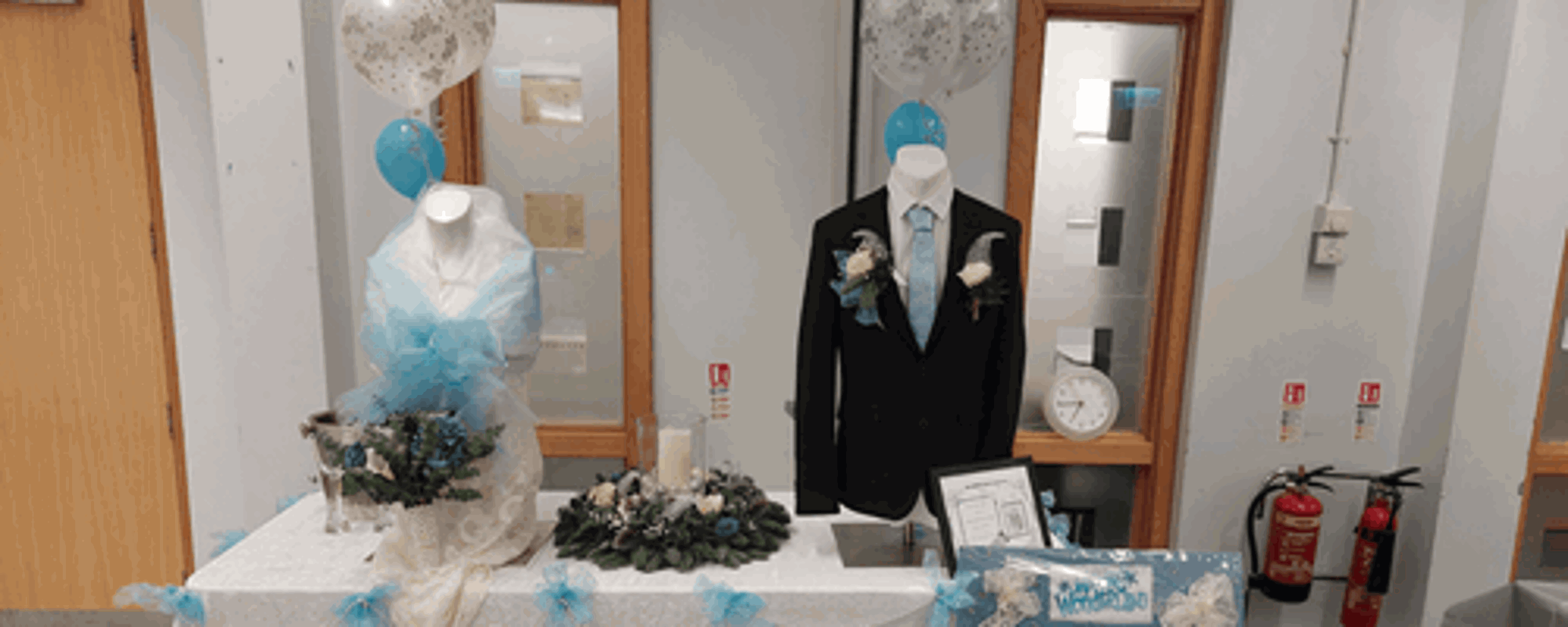 Suit and wedding dress with flowers on table